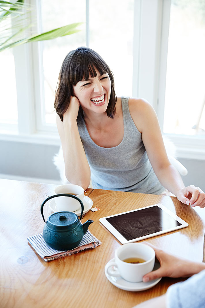 Woman laughing with ipad  | Trinette+Chris Photographers