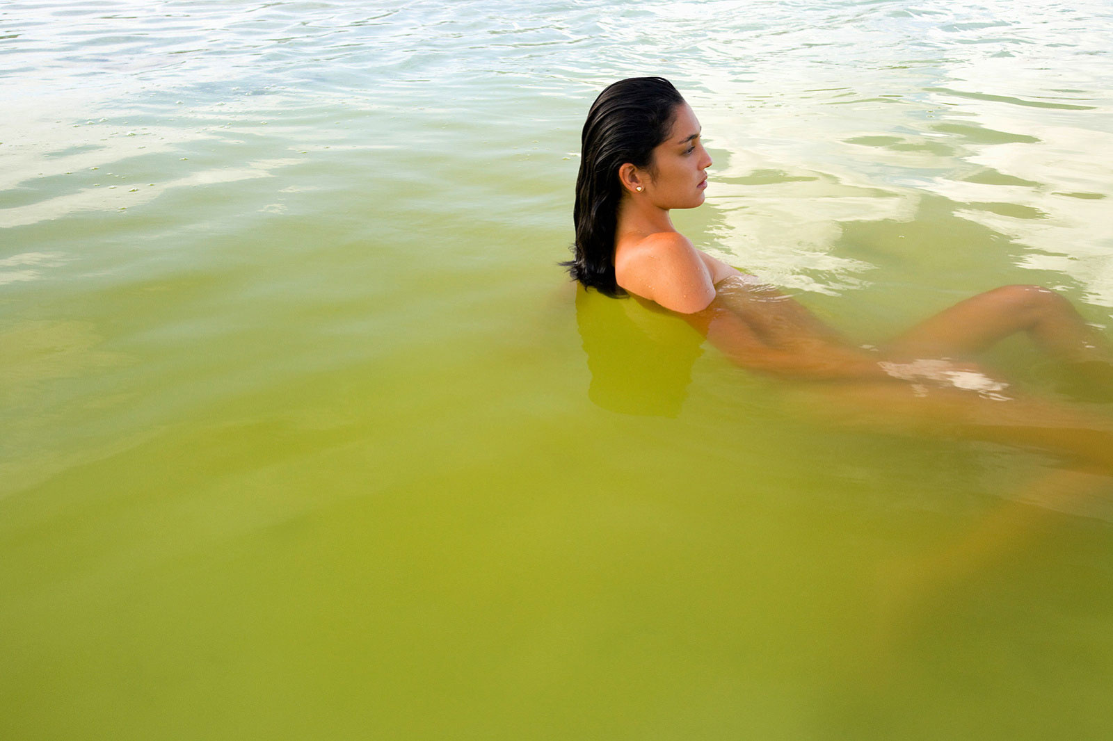 Woman floating in water in Tahiti | Trinette + Chris Photographers